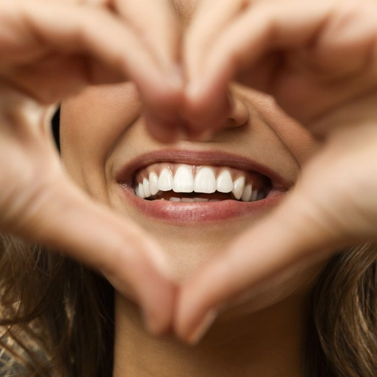 Un sourire, encadré par des mains qui forment un cœur